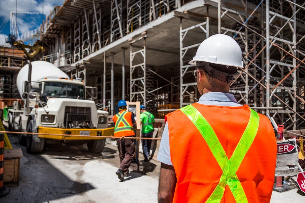 Construction worker standing at construction site with semi truck